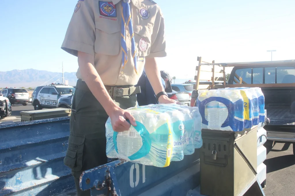 School Water, Student Habits: What the Bottled Water Survey Means for Classrooms A young scout handing out donated bottled water - School Water, Student Habits: What the Bottled Water Survey Means for Classrooms